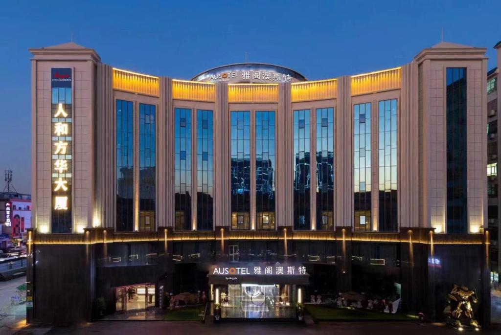 un grand bâtiment avec beaucoup de fenêtres la nuit dans l'établissement Ausotel by Argyle Baiyun International Airport Renhe Metro Exit B, à Canton