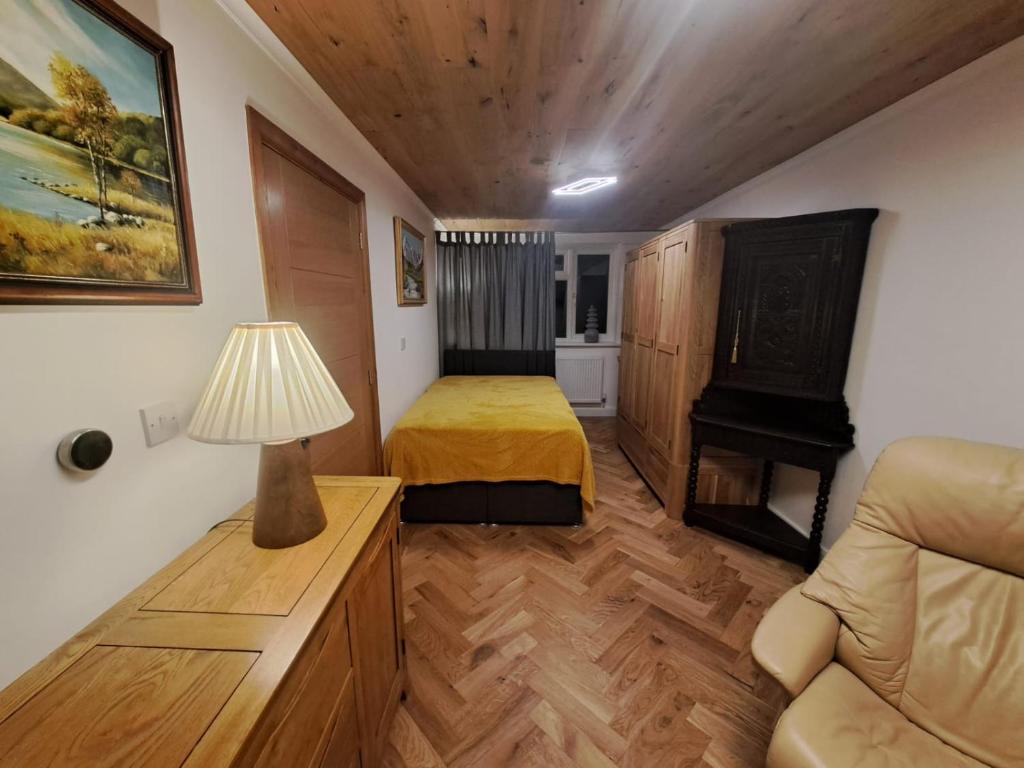 1 dormitorio con 1 cama, 1 sofá y 1 lámpara en Serviced Studio in Bournville, en Birmingham