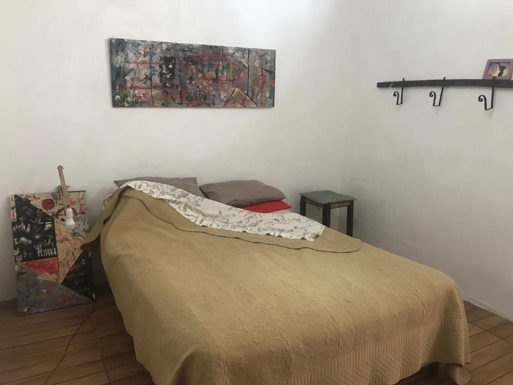 a bedroom with a bed and a painting on the wall at Humilde espacio en el corazón de Minas in Minas