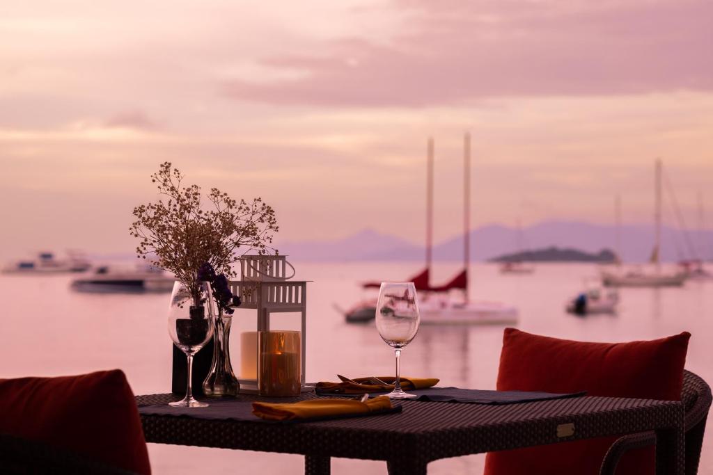 a table with two wine glasses and a view of the water at The Culture Samui in Bangrak Beach