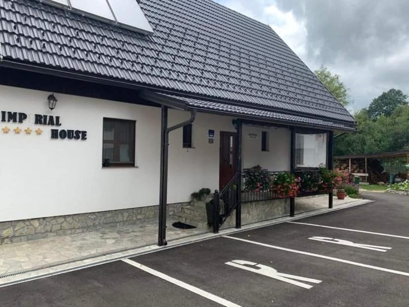 a parking lot in front of a white building at Rooms Imperial House in Plitvička Jezera