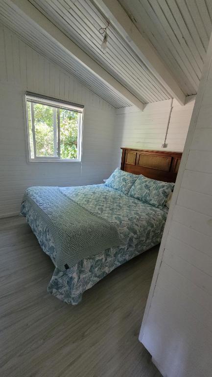 1 dormitorio con 1 cama en una habitación con ventana en Acogedora casa de huéspedes, climatizada., en Los Ángeles
