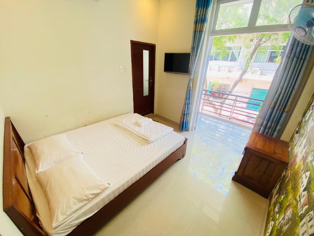 1 dormitorio con cama y ventana grande en Aloha Hotel en Phan Rang