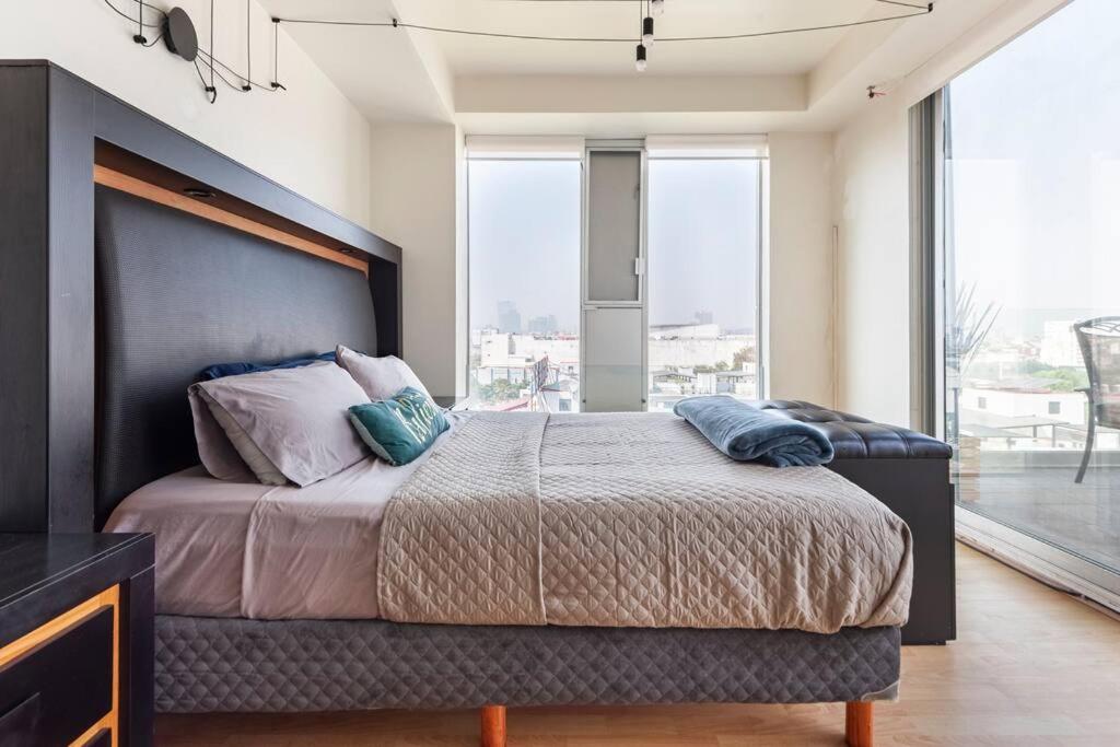 a bedroom with a large bed with a large window at Sky Coyoacan Depto con terraza privada in Mexico City