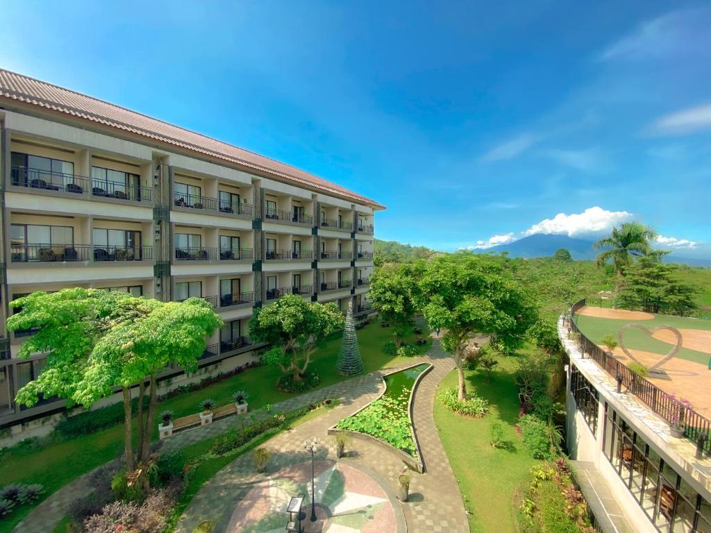 an apartment building with a park in front of it at The Green Peak, ARTOTEL Curated in Cisarua