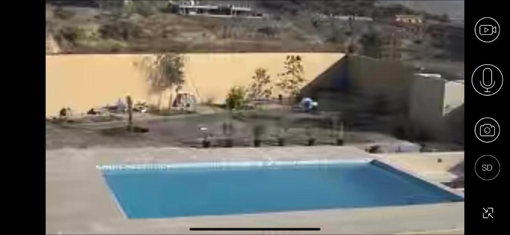 SharīyahAl Ghadeer Maison Masfout的院子里游泳池的视频