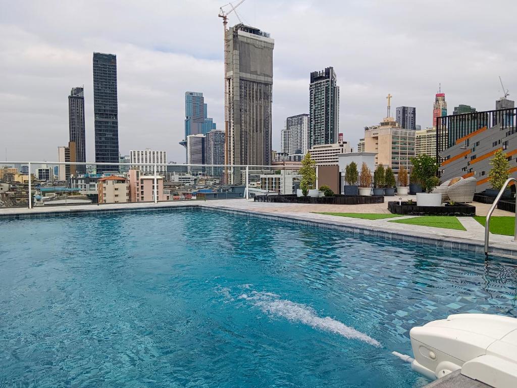 a swimming pool with a city skyline in the background at S3 Siam Bangkok Hotel in Bangkok
