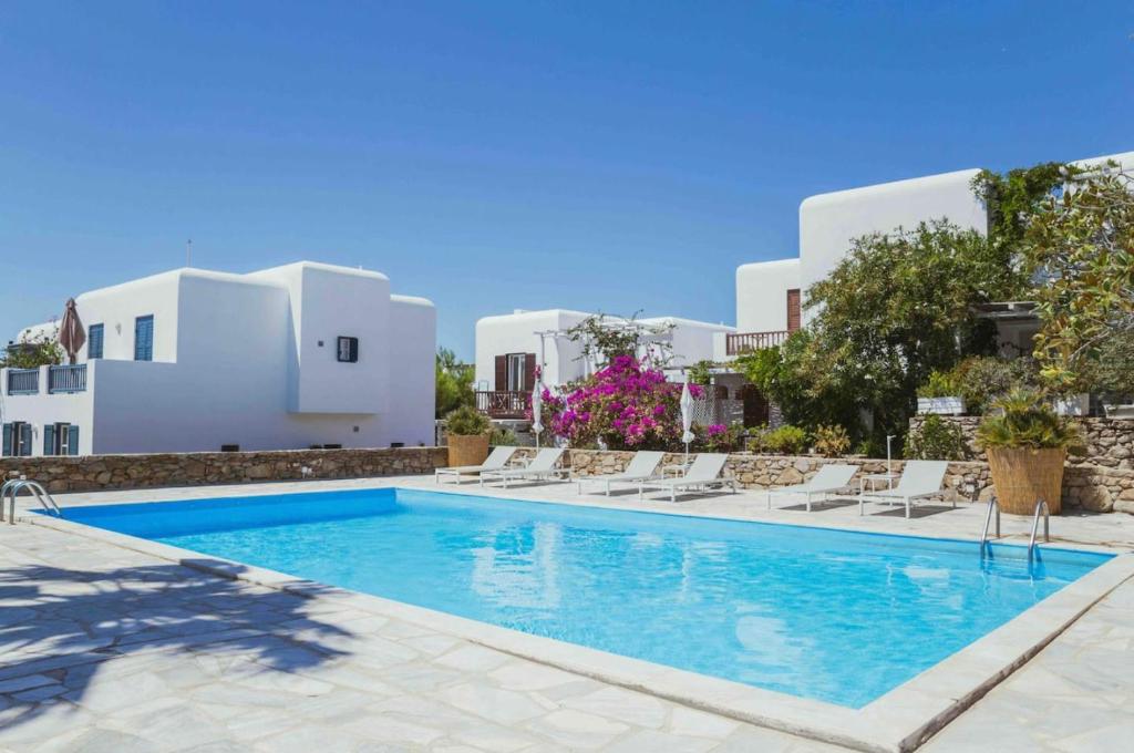 a view of a swimming pool with chairs and buildings at Private Town Apartments by Mykonos Eight in Mikonos