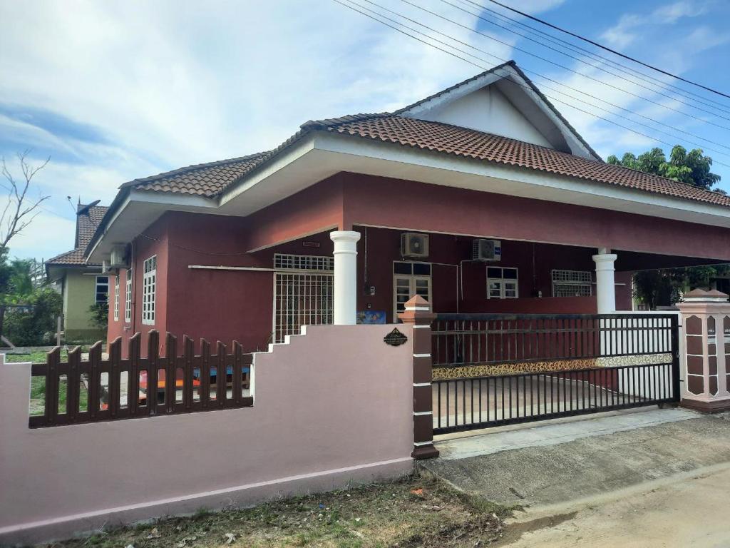 ein Haus mit einem Zaun davor in der Unterkunft MUAZDIANA HOMESTAY di KUALA NERUS, GONG BADAK in Kampong Tanjong Gelam