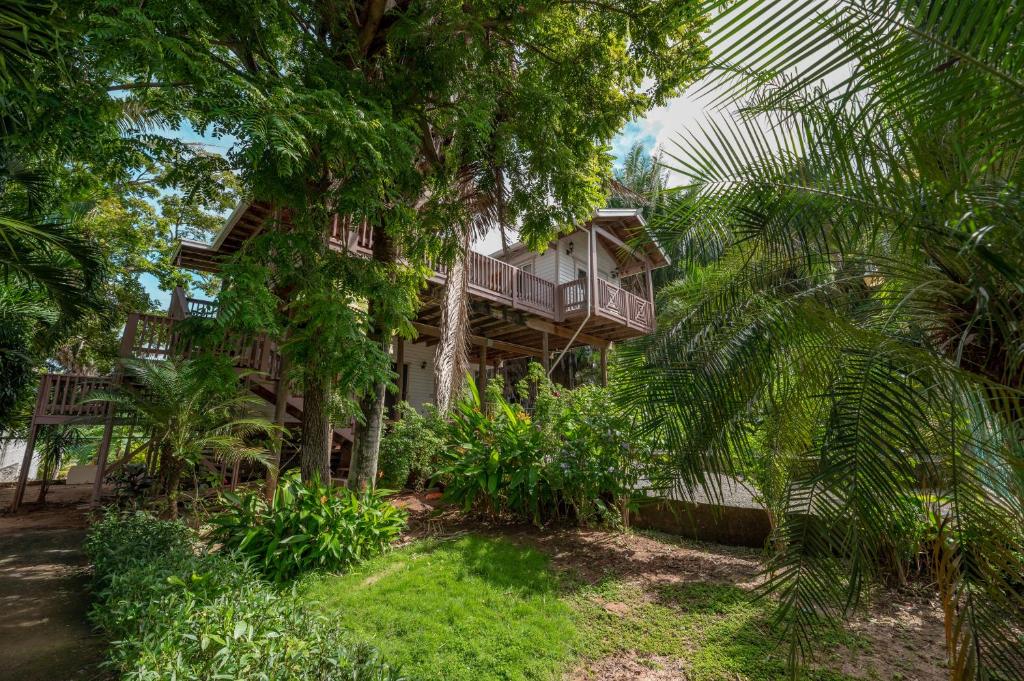 a house with a balcony in the middle of trees at Exclusive Full House - 3 BDRM & 3 BATH - 3min Beach in Roatan