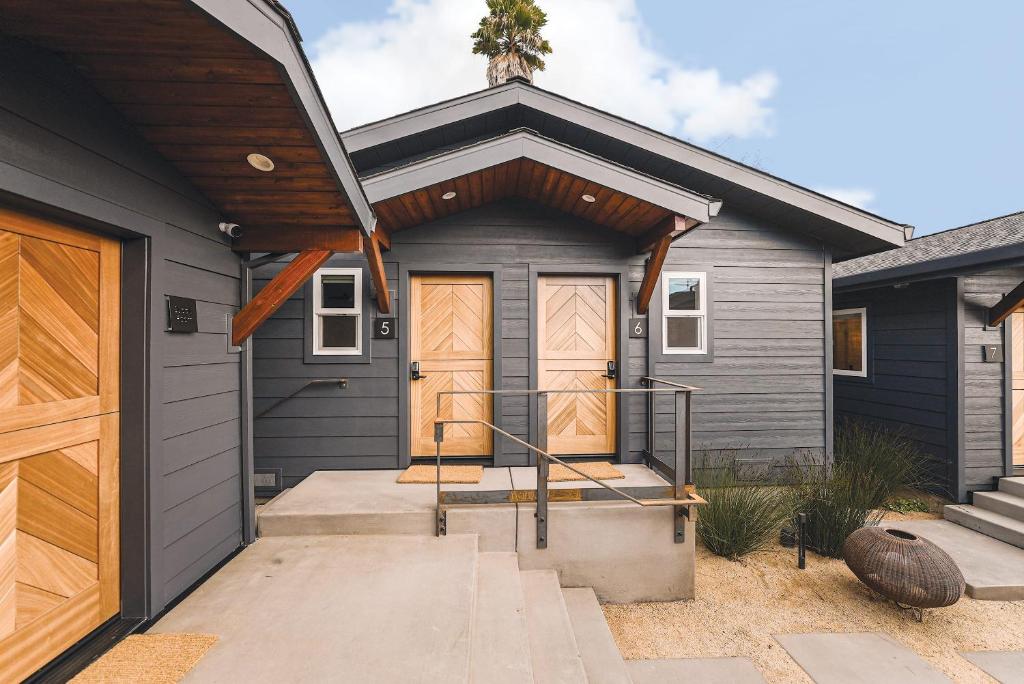 a gray house with wooden doors and a porch at Shortboard Room includes Queen Bed in Stinson Beach