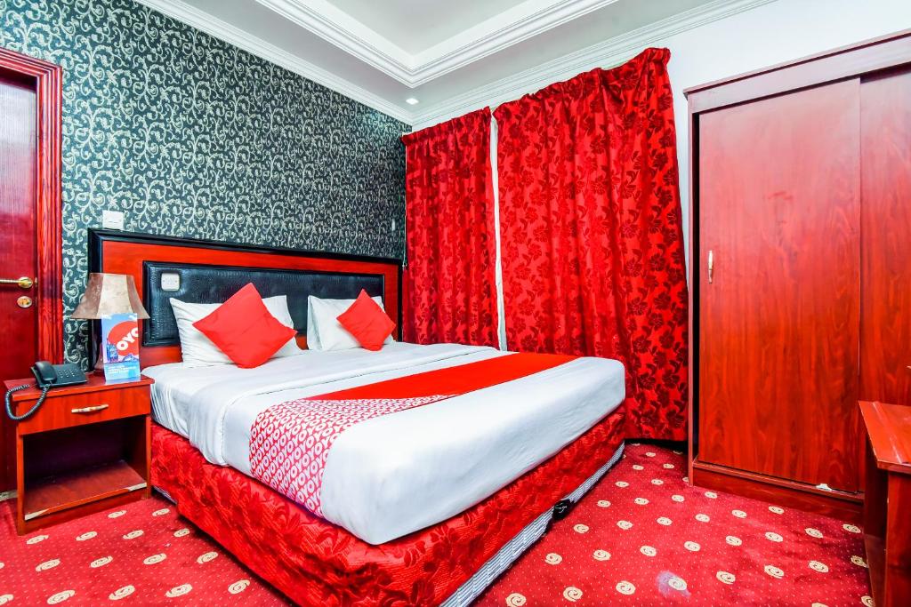 1 dormitorio con 1 cama grande y cortinas rojas en OYO 492 Gulf Star, en Dubái