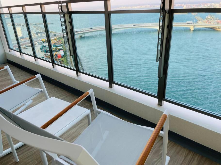 a balcony with chairs and a view of the water at 1204 ブランシエラ那覇曙プレミスト in Nakanishi
