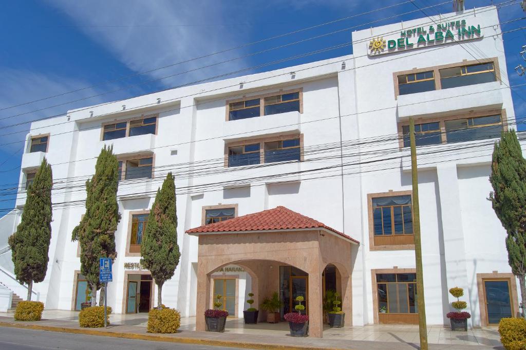 a white building with an arch in front of it at Hotel del Alba Inn & Suites in Aguascalientes