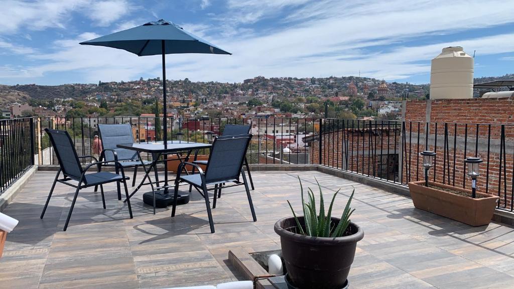 patio con tavolo, sedie e ombrellone di Casa El Arte de Frida a San Miguel de Allende
