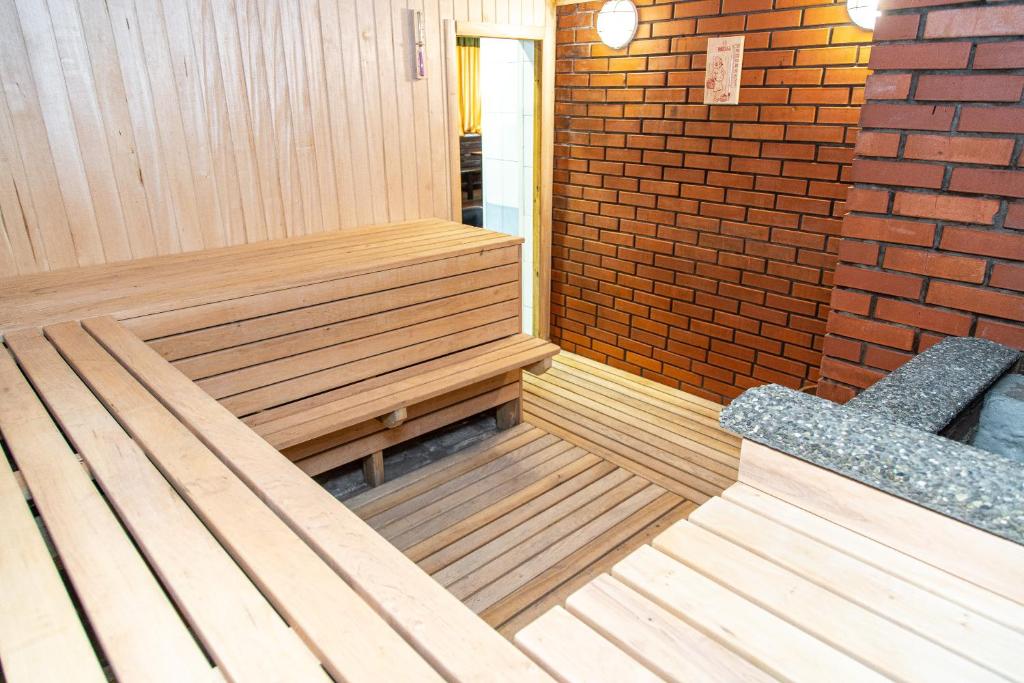 a sauna with a bench and a brick wall at Готель «На Кронштадській» in Avtozavodskiy Rayon