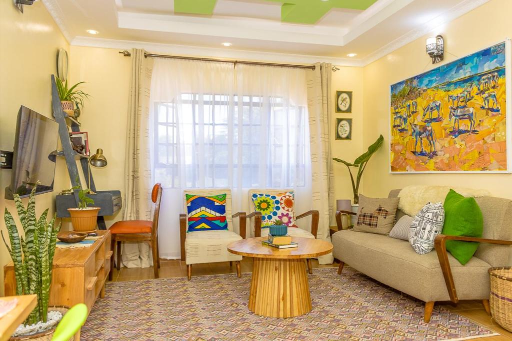 a living room with a couch and a table at Kenai Stay, Secluded 1 bedroom with free parking in Nanyuki