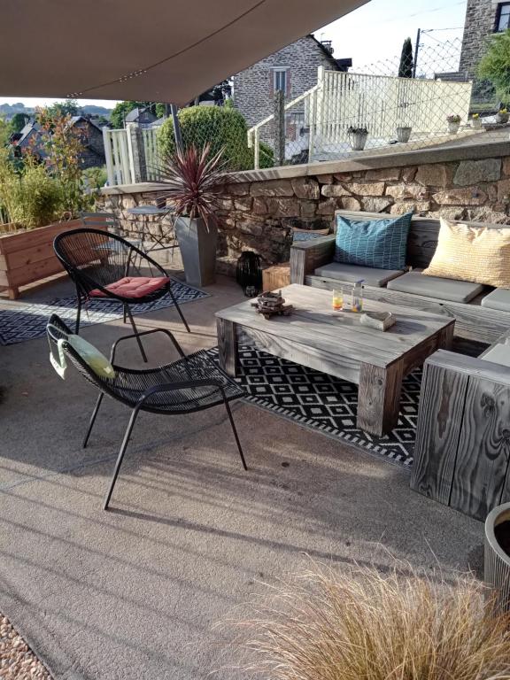 a patio with a table and chairs and a bench at Le 28 in Uzerche