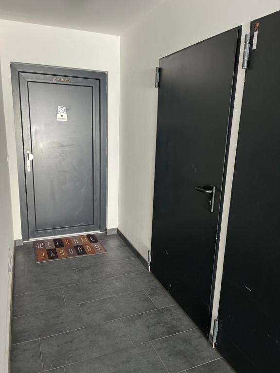two black doors in a room with a tile floor at Ferienwohnung Fischerweg in Bodensdorf