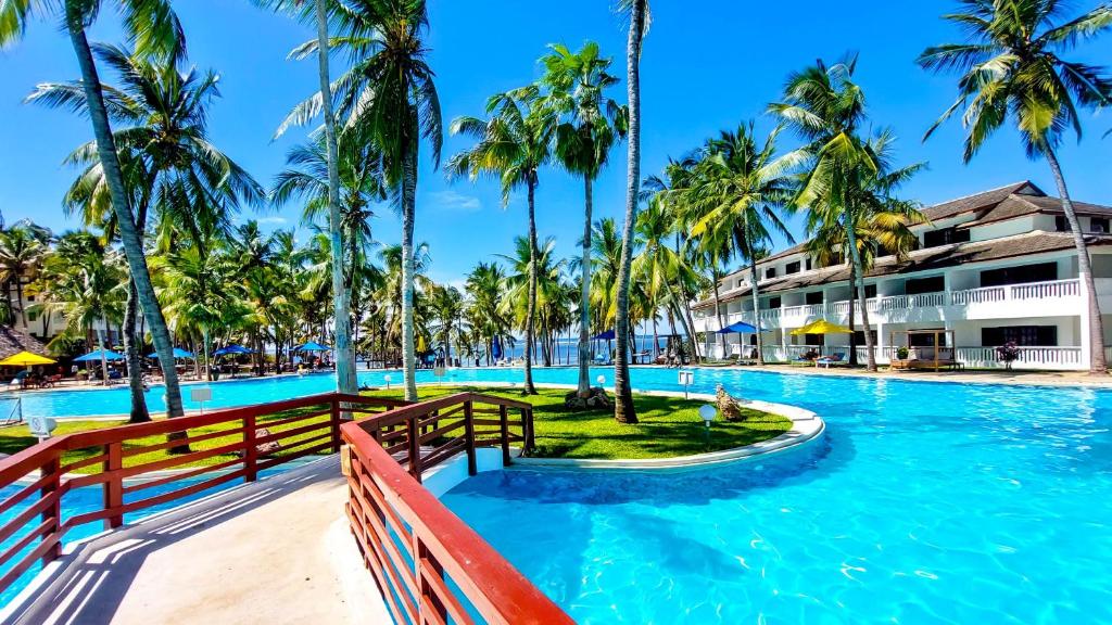 a pool at the resort with palm trees at PrideInn Flamingo Beach Resort & Spa Mombasa in Mombasa