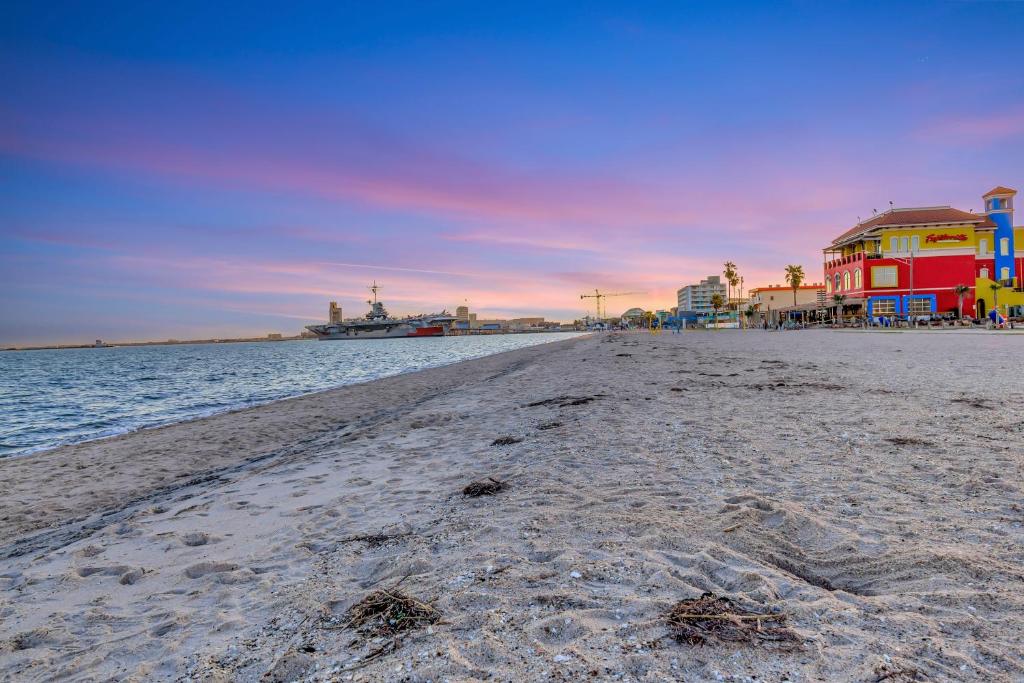 a sandy beach with a boat in the water at Beach View & SeaBreezes in Corpus Christi