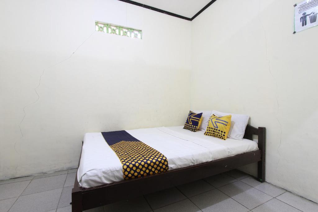 - un lit dans une chambre avec 2 oreillers dans l'établissement OYO 92231 Penginapan Tanjung Alang Syariah, à Makassar