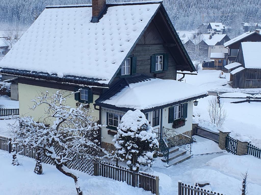 een huis met sneeuw op het dak bij Ferienhaus Waldglück in Gosau