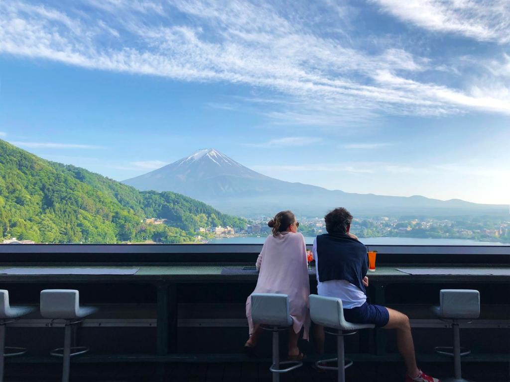 富士河口湖的住宿－水之家酒店，两个人坐在椅子上,看着山