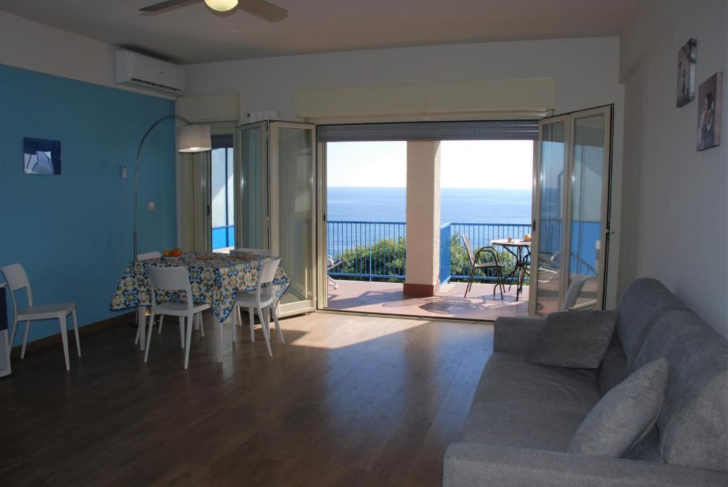 a living room with a couch and a table with a view at Casa Il Delfino in Aci Castello
