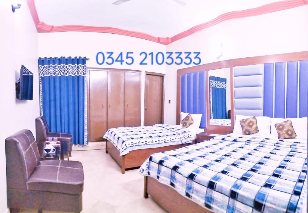 a bedroom with two beds and a chair in it at Gulshan Palace Near Millennium Mall Agha khan Hospital Airport Karachi in Karachi