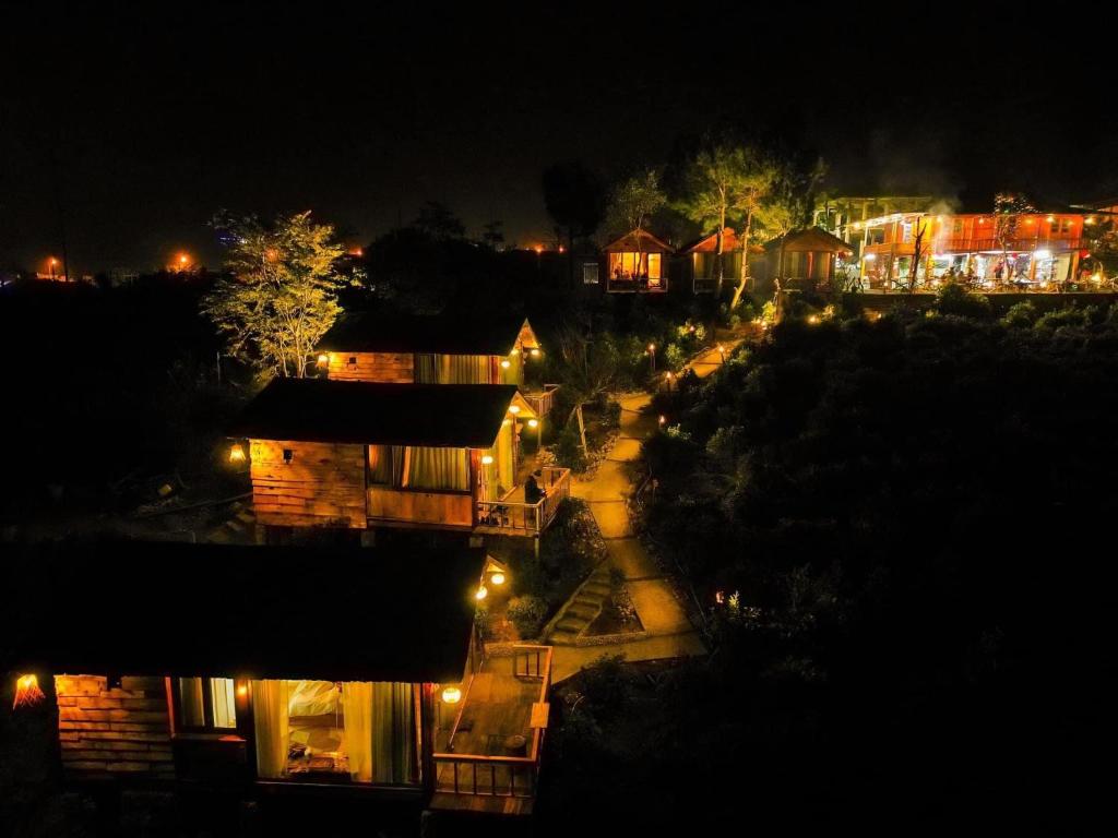 a city at night with lights on a street at Na Thẩm Eco Hill Homestay - Trạm Tấu in Cham Ta Lao