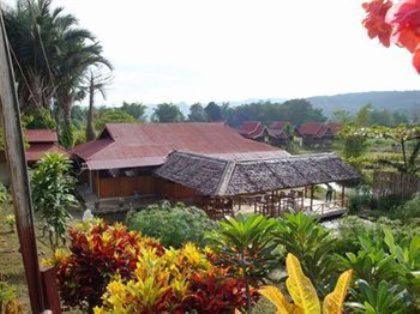 uma casa com telhado e um jardim com plantas em Ue Datu Cottages em Tentena