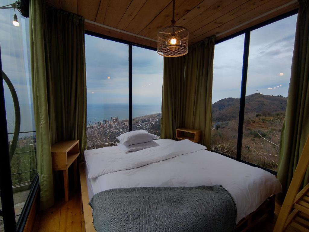 a bedroom with a bed in front of a large window at Limoncello in Batumi