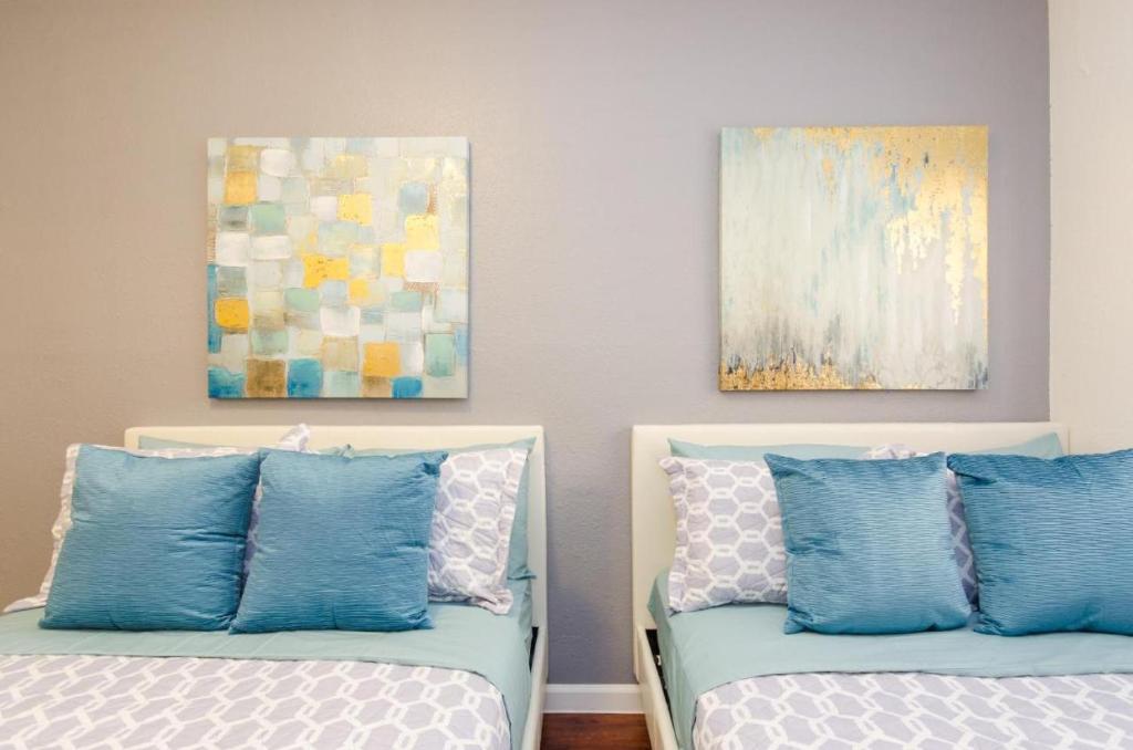 two beds with blue and white pillows in a room at Cute Studio in the Heart of Hollywood in Los Angeles