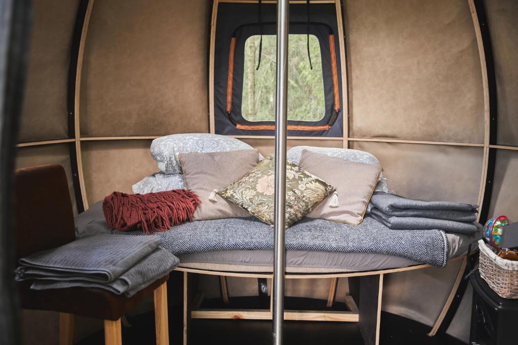 un grupo de almohadas sentado en una mesa en una caravana en Nature calls - tree tents en Būtingė