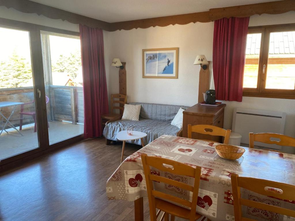 un salon avec une table et un canapé dans l'établissement Appartement cosy 4 pers, balcon, parking gratuit, proche pistes - FR-1-504-655, à Saint-Étienne-en-Dévoluy