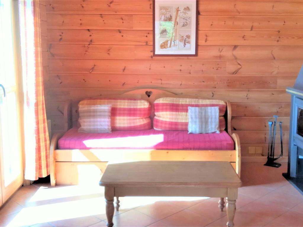 a couch in a log cabin with a coffee table at Chalet La Joue du Loup, 3 pièces, 6 personnes - FR-1-504-638 in Le Dévoluy