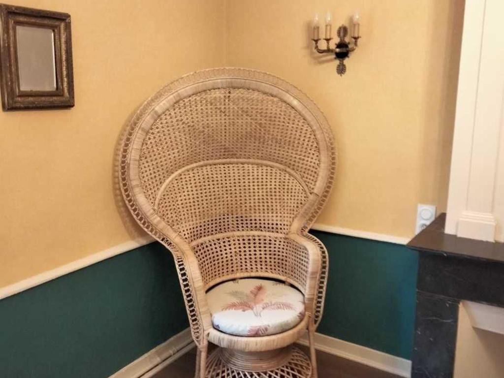 a wicker chair sitting in a corner of a room at Gîte Bazouges-sur-le-Loir, 6 pièces, 10 personnes - FR-1-410-377 in Bazouges-sur-le-Loir