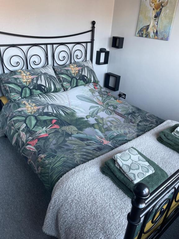 1 dormitorio con 1 cama con colcha de flores en 27 The Limes Room 1 en Stockton on the forest