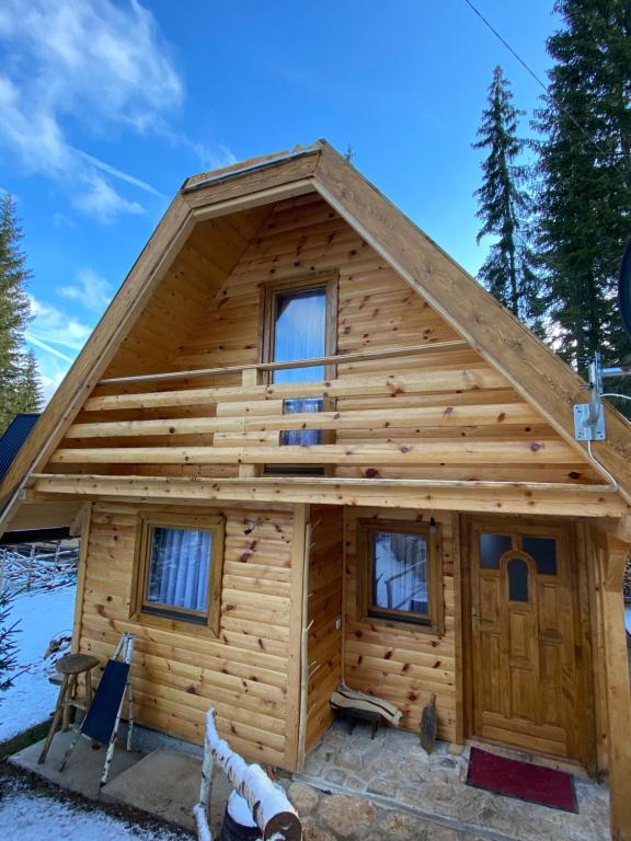 uma cabana de madeira com uma porta grande em Etno kuća ''Nada'' em Jahorina