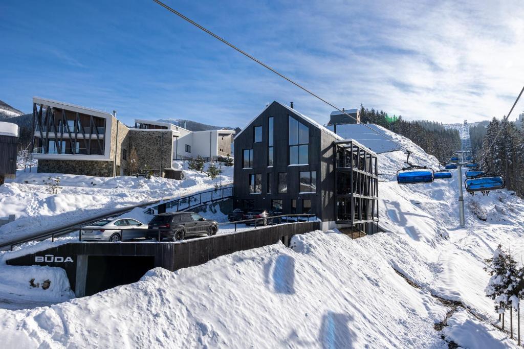 a house in the snow with a ski lift at BÚDA Jasná in Demanovska Dolina