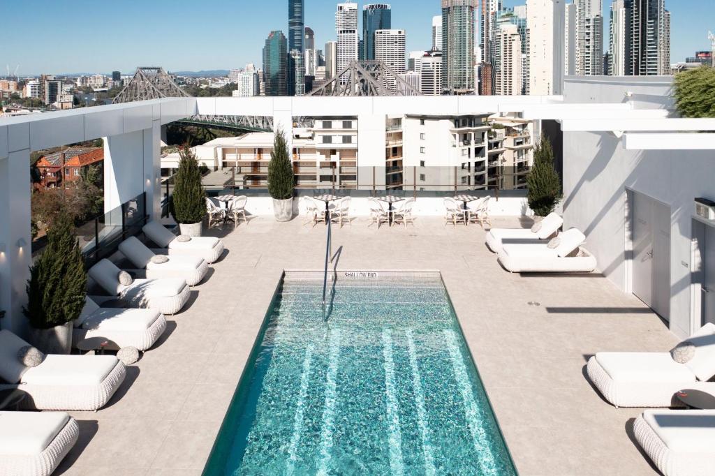 a swimming pool on the roof of a building with lounge chairs at Hotel X Brisbane Fortitude Vly, Vignette Collection - an IHG Hotel in Brisbane