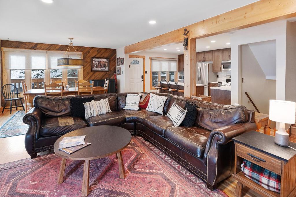 a living room with a leather couch and a table at Winterset 8 Pet Friendly townhouse in Steamboat Springs
