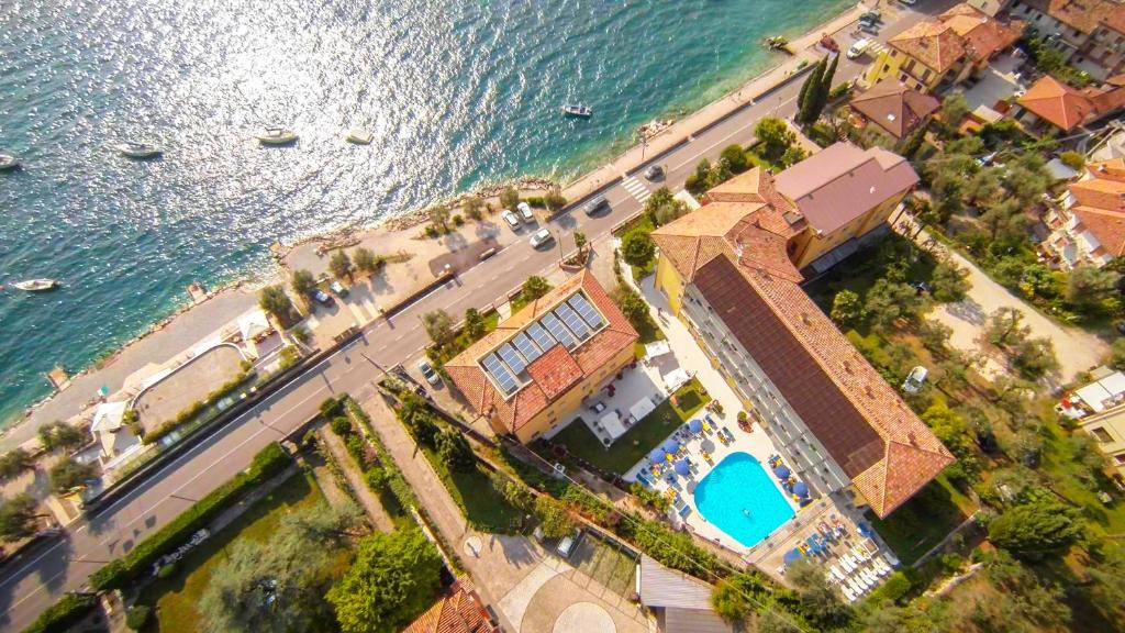 an aerial view of a building next to the water at Hotel Drago - Garda Lake Collection in Brenzone sul Garda