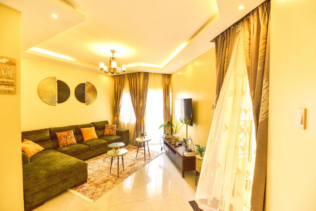 sala de estar con sofá verde y cortinas en Willington Haven, en Kampala