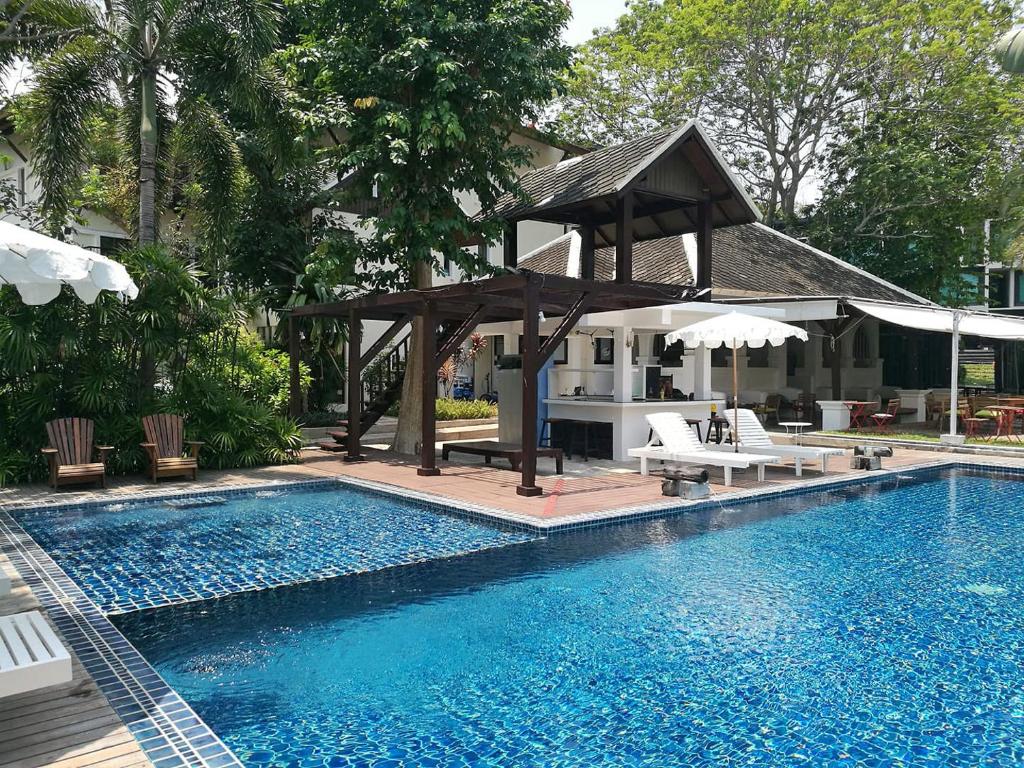 a swimming pool with a gazebo next to a house at Sandhana Samet Resort in Ko Samed