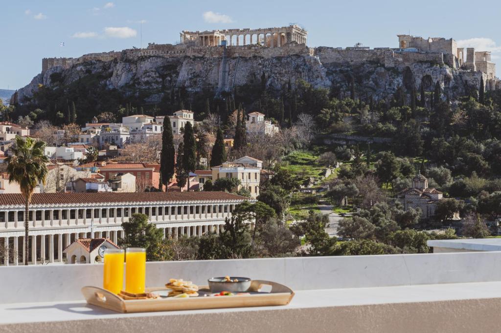 a tray of food on a ledge with a view of the city at Altar Suites in Athens