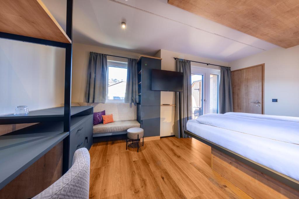 ein Schlafzimmer mit einem großen Bett und einem Sofa in der Unterkunft PEOPLE'S Hotel in Kaprun