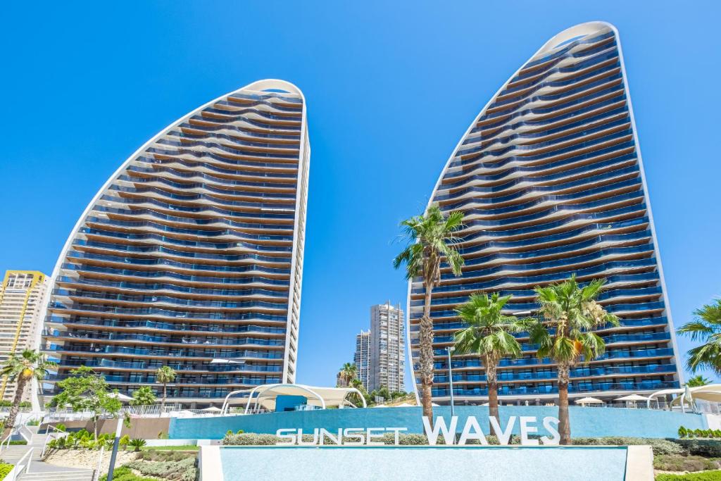 zwei hohe Gebäude in einer Stadt mit Palmen in der Unterkunft Sunset Waves 3-194 Poniente Beach Resort in Benidorm