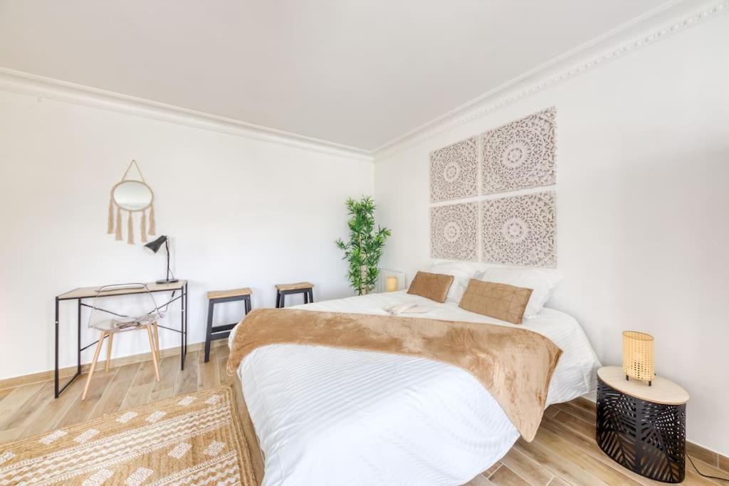 Dormitorio blanco con cama y mesa en STUDIO VUE DIRECT SUR LE PORT DE CERGY, Parking Privé Gratuit en Cergy